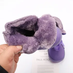 Detail view of the thick purple faux fur lining inside children warm winter snow boots