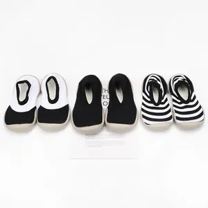 Detail of three pairs of breathable baby sock shoes in various black and white patterns.