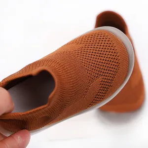 Detailed close-up of breathable knit texture on brown baby soft-sole sock shoes.