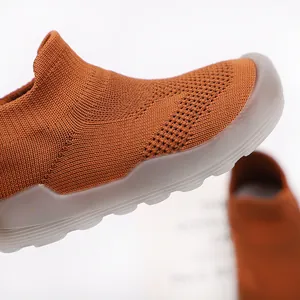 Close-up detail of the breathable knitted fabric and soft non-slip sole on toddler shoe