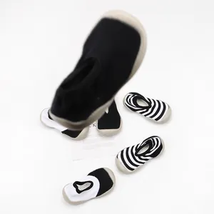 Detail view of breathable soft-sole baby sock shoes in black and white stripes