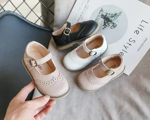 Detail of girls' Japanese style Mary Jane leather shoes in pink, white, and black.