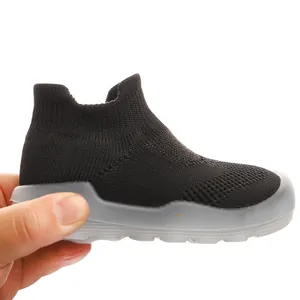 Close-up detail of a breathable black knit baby sock shoe with a flexible grey soft sole