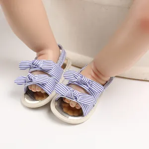 Vue détaillée de sandales pour bébé à rayures bleues et blanches avec nœuds
