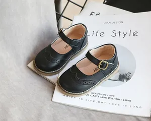 Close-up view of black Mary Jane leather shoes for girls with elegant brogue detailing