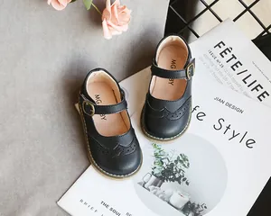 Detail view of black Mary Jane shoes for girls featuring brogue patterns and buckles