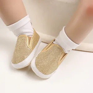 Dettaglio di scarpine primi passi glitterate oro con suole bianche morbide