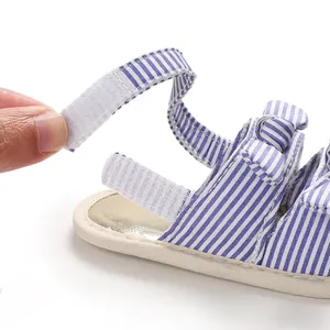 Détail de la fermeture auto-agrippante sur les sandales pour bébé à rayures bleues