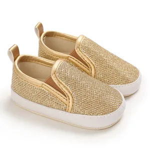 Dettaglio ravvicinato scarpe neonato glitter oro con suole morbide bianche antiscivolo