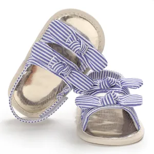 Vue détaillée de sandales pour bébé à rayures bleues avec des nœuds décoratifs