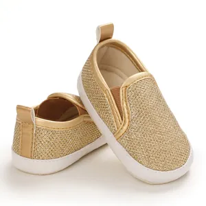 Vista dettagliata delle scarpe primi passi dorate glitterate per neonati con suole bianche
