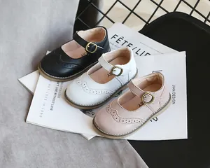 Detail view of girl's vintage brogue Mary Jane shoes in black, white, and pink.