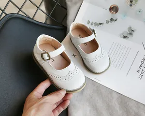 Close-up of white Mary Jane shoes for girls featuring brogue detailing and soft sole