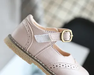 Close-up detail of soft pink leather girl's Mary Jane shoes with buckle and velcro strap