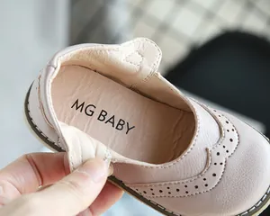 Close-up detail of soft pink leather girl's shoe with elegant brogue pattern and MG BABY logo