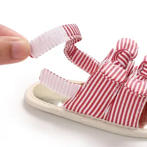 Vue détaillée de la fermeture velcro réglable sur des sandales pour bébé à rayures.