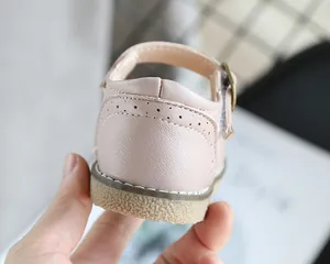 Close-up back view of soft pink toddler leather shoes featuring durable rubber soles