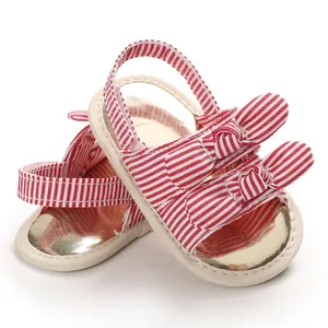 Gros plan de sandales de marche pour bébé respirantes avec nœud rayé rouge et blanc