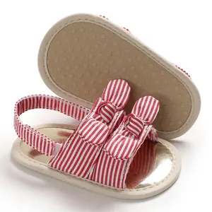 Détail des sandales pour bébé à rayures rouges avec semelles souples antidérapantes.