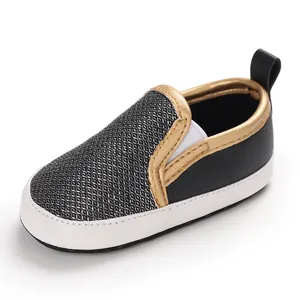 Dettaglio scarpe primi passi nere per neonati con bordo oro e suola antiscivolo