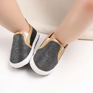 Vista dettagliata delle scarpe da passeggio per neonati con bordo dorato e suole morbide