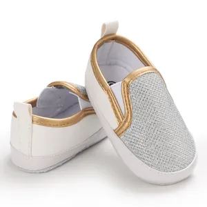 Dettaglio di scarpe per neonati con pannello glitter argento e rifiniture dorate
