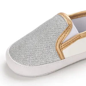 Dettaglio scarpa neonato con punta glitter argento e finiture color oro eleganti