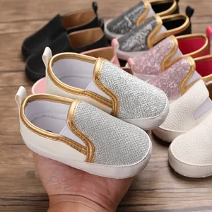 Primo piano di scarpe primi passi glitterate per neonati con suole antiscivolo morbide