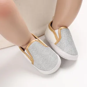 Vista dettagliata di scarpe primi passi glitter argento con piping oro su suola bianca