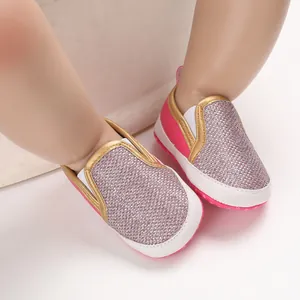 Dettaglio ravvicinato di scarpe primi passi rosa glitterate con suole morbide antiscivolo