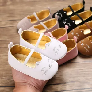 Close-up view of a soft white baby walker shoe featuring a cute cat face embroidery and gold lining