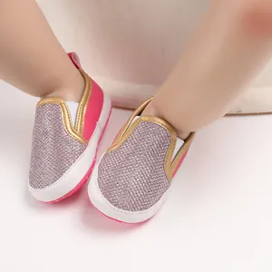 Dettaglio scarpe primi passi per neonati glitter rosa e argento con suola bianca morbida