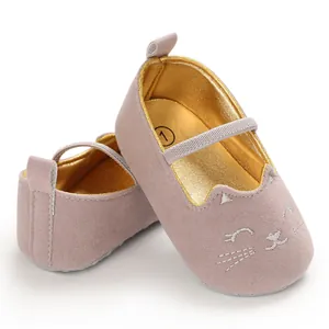 Close-up detail of pink baby pre-walker shoes featuring cat embroidery and gold insole