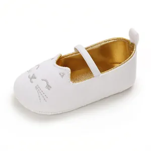 Detail view of the cute silver cat face embroidery on a white infant walker shoe.