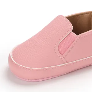 Dettaglio macro di scarpe da camminata per neonati in ecopelle rosa con suola morbida ed elastico