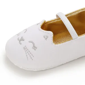 Macro view of cute silver cat face embroidery on white soft-sole infant walker shoes