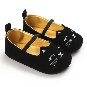 Close-up of black baby walking shoes with cute cat embroidery and soft gold lining.