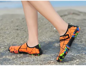 Seitendetail oranger Outdoor-Wasserschuhe mit Sportriemen auf felsigem Gelände