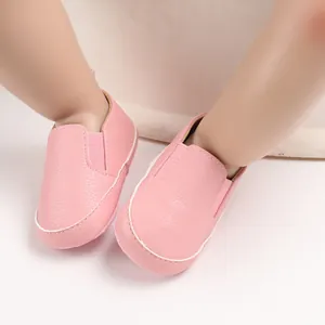 Dettaglio di scarpine primi passi rosa in ecopelle con suole morbide per neonati.