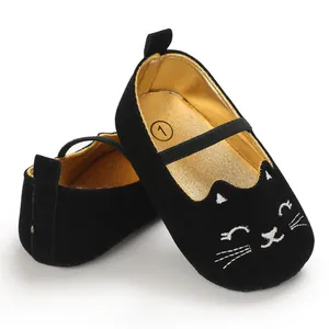 Detailed view of black baby walking shoes featuring a cute embroidered cat face and gold interior.