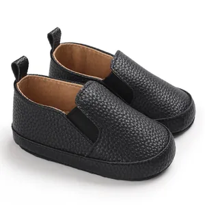 Dettaglio della pelle nera martellata su scarpe da passeggio per neonati slip-on