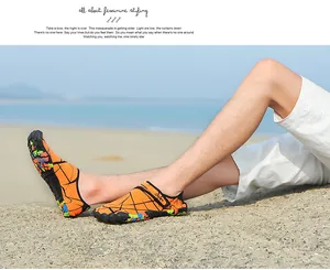 Detailansicht oranger Wasserschuhe am Strand, zeigt Griffigkeit und modisches Design