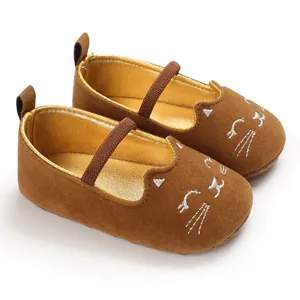 Close-up of brown baby walking shoes with cute embroidered cat face and soft soles