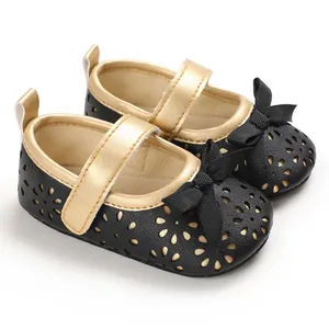 Detailansicht schwarzer Baby-Prinzessin-Schuhe mit goldenem Futter und Zierschleife