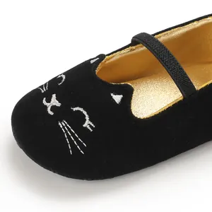 Detail view of black velvet infant walking shoes featuring embroidered white cat