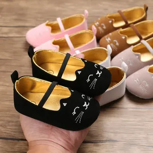 Detail of soft-sole baby pre-walker shoes with cute cartoon cat embroidery design.