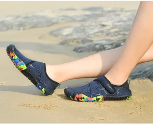 Nahaufnahme von atmungsaktiven Mesh-Outdoor-Aquaschuhen an einem sonnigen Sandstrand