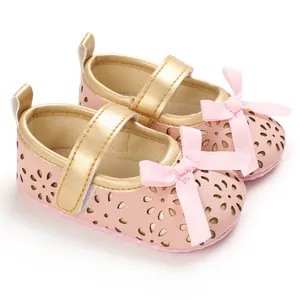 Detail von rosa Baby-Prinzessin-Schuhen mit goldenem Rand und lasergeschnittenen Blumen