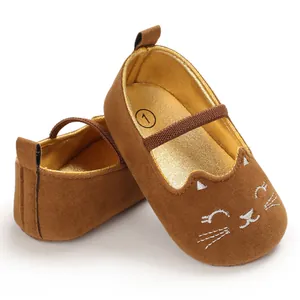 Close-up view of brown suede baby pre-walker shoes with an embroidered white cat face.