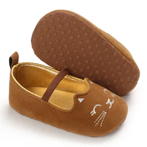 Detailed macro view of brown baby walking shoes with cat face embroidery and non-slip sole.
